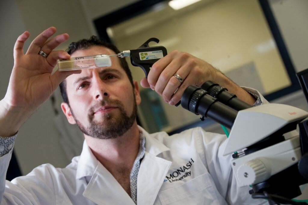 Dr. Damian Dowling, Australian Research Fellow, Monash School of Biological Sciences; Damien pictured in the lab with fruit flies. He is studying the genetics of these flies.