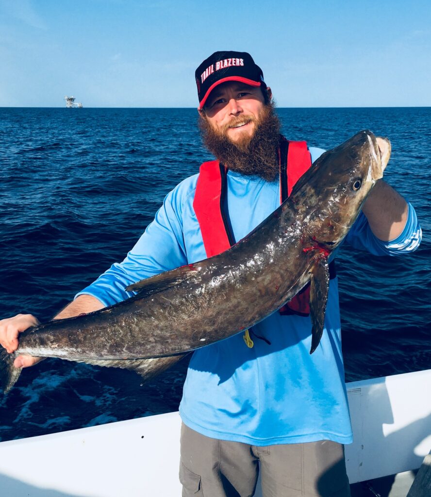 Ryan Easton on a fishing trip in the Gulf of Mexico, off the coast of Central Texas, holding a cobia (Rachycentron canadum).